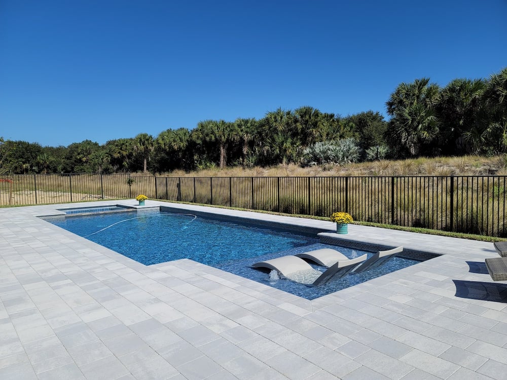 Geometric pool with travertine deck and raised spa